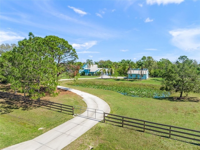 view of community with a yard, a fenced front yard, and a gate