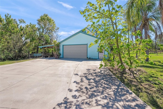 exterior space with a carport, an attached garage, and driveway