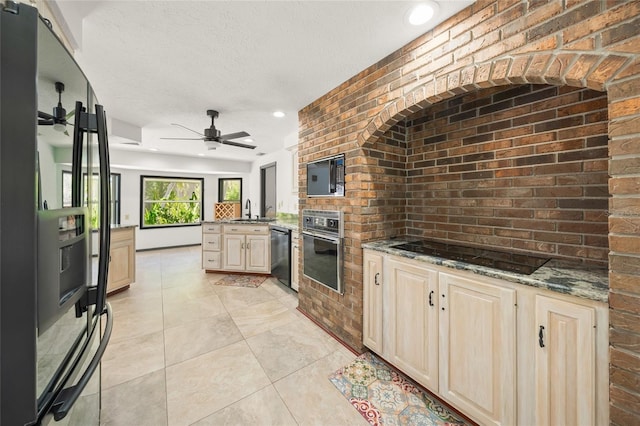 kitchen featuring black appliances, a peninsula, brick wall, and a sink