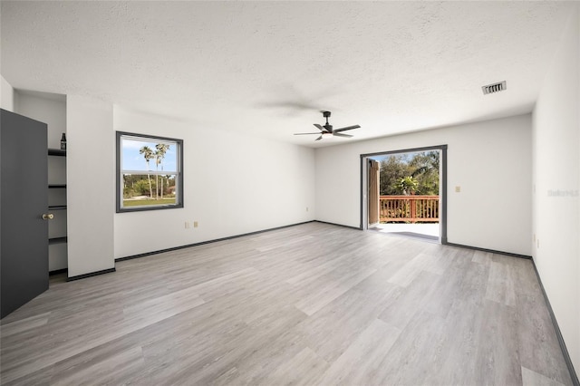 unfurnished living room featuring a ceiling fan, light wood-style floors, visible vents, and a textured ceiling