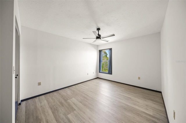 spare room with a ceiling fan, wood finished floors, baseboards, and a textured ceiling