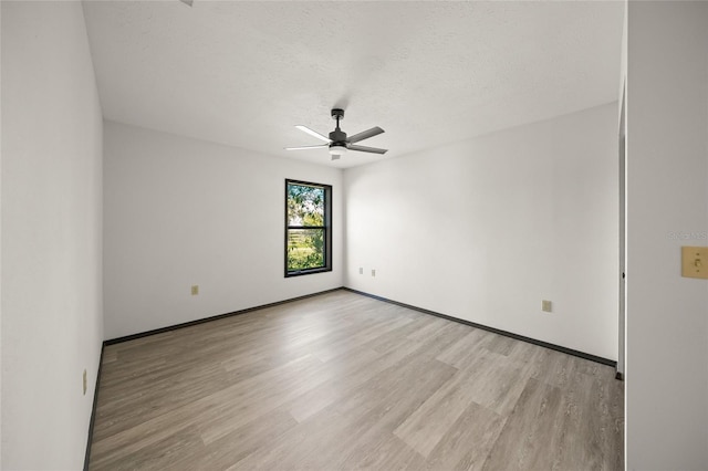 empty room with light wood-type flooring, baseboards, a textured ceiling, and ceiling fan