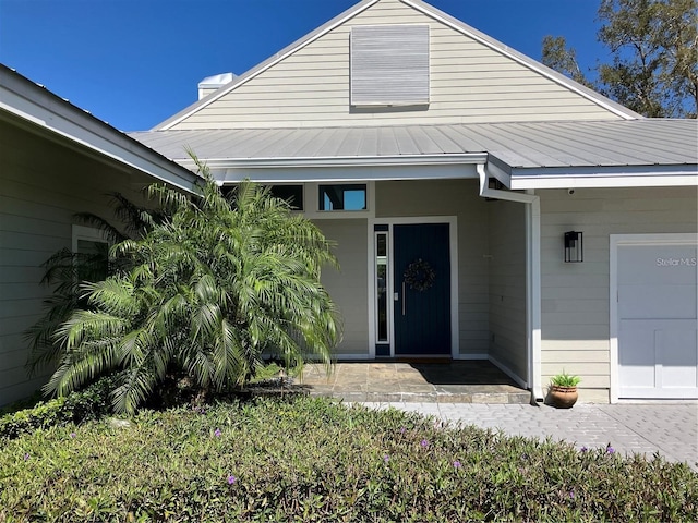 view of exterior entry featuring metal roof