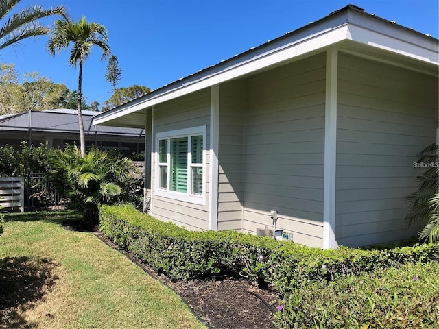 view of side of property featuring a lawn and fence