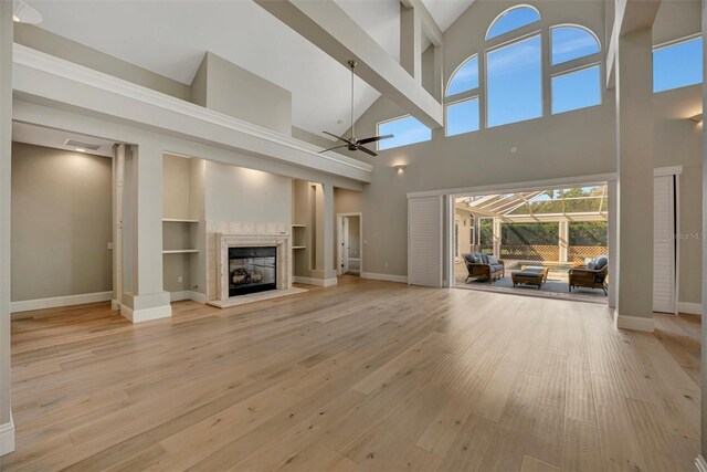 unfurnished living room featuring a ceiling fan, a high end fireplace, baseboards, visible vents, and light wood-style floors