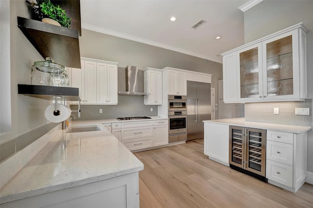 kitchen with white gas cooktop, ornamental molding, double oven, visible vents, and wall chimney exhaust hood