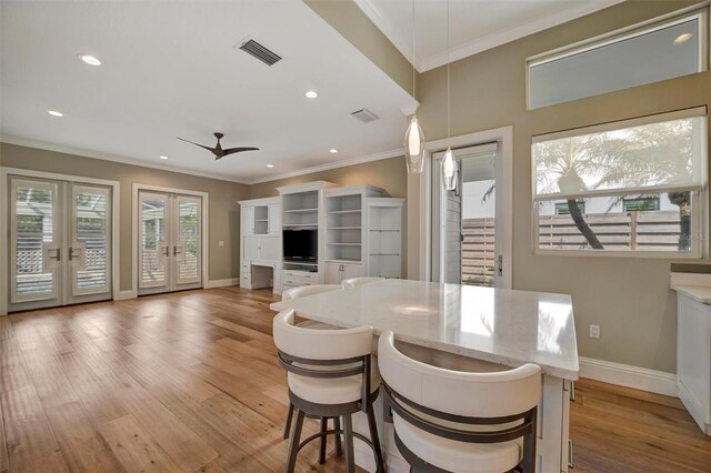 dining area featuring french doors, ornamental molding, ceiling fan, light wood-style flooring, and visible vents