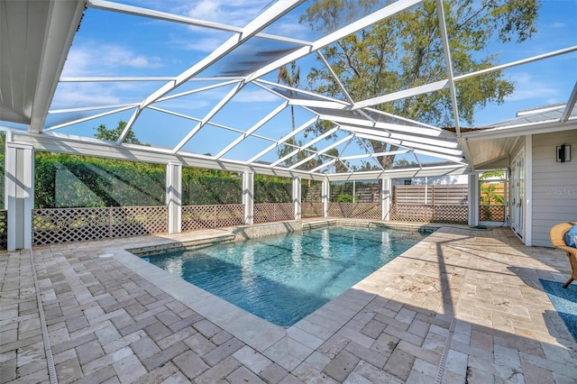 view of swimming pool with a fenced in pool, glass enclosure, and a patio area