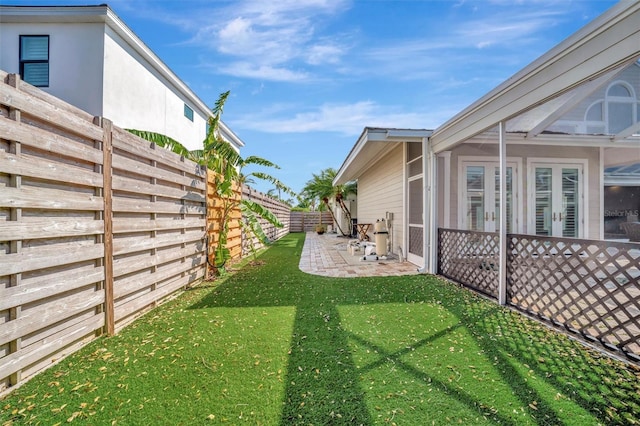 view of yard featuring a fenced backyard, french doors, and a patio area