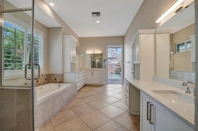 bathroom featuring tile patterned flooring, a sink, a bath, and visible vents