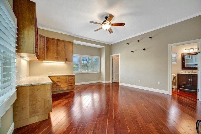 interior space with baseboards, ceiling fan, ornamental molding, and dark wood-style flooring