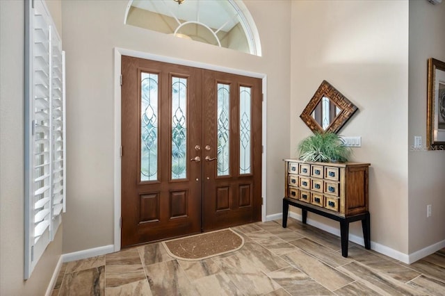 entryway featuring a high ceiling and baseboards