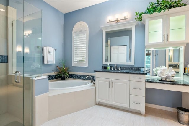 bathroom featuring vanity, a bath, a stall shower, and plenty of natural light