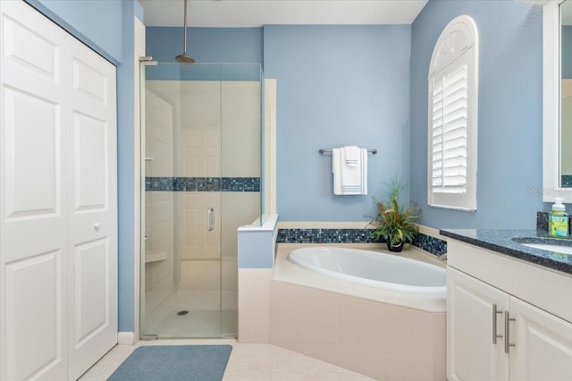 full bathroom featuring tile patterned floors, a stall shower, vanity, and a garden tub