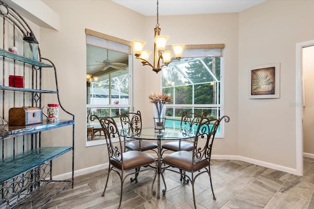 dining area with ceiling fan with notable chandelier and baseboards