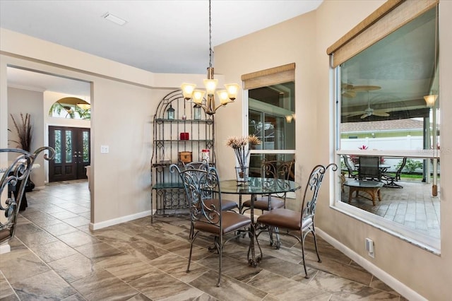 dining space with baseboards, a notable chandelier, and a healthy amount of sunlight