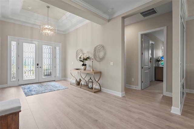 foyer with visible vents, ornamental molding, wood finished floors, french doors, and an inviting chandelier