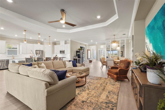 living area with crown molding, ceiling fan, recessed lighting, light wood-style floors, and a raised ceiling