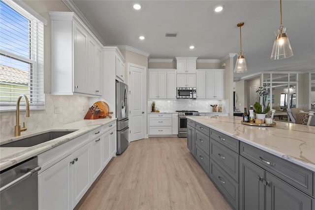 kitchen with a sink, white cabinetry, appliances with stainless steel finishes, and gray cabinetry