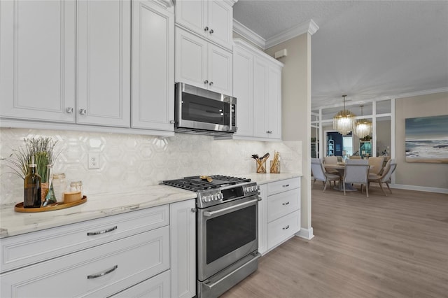 kitchen featuring crown molding, backsplash, light stone countertops, and appliances with stainless steel finishes