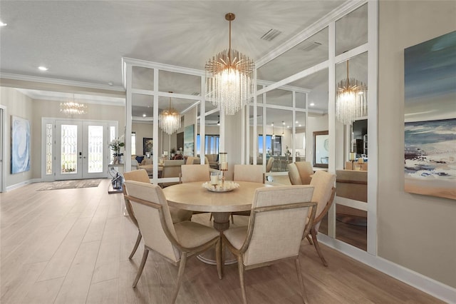 dining area with visible vents, ornamental molding, french doors, an inviting chandelier, and wood finished floors