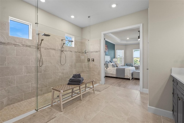 ensuite bathroom with connected bathroom, baseboards, vanity, and a walk in shower