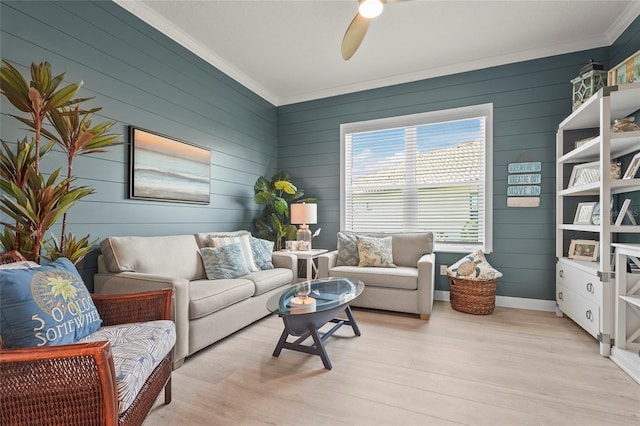 living room featuring ceiling fan, light wood-style flooring, baseboards, and ornamental molding