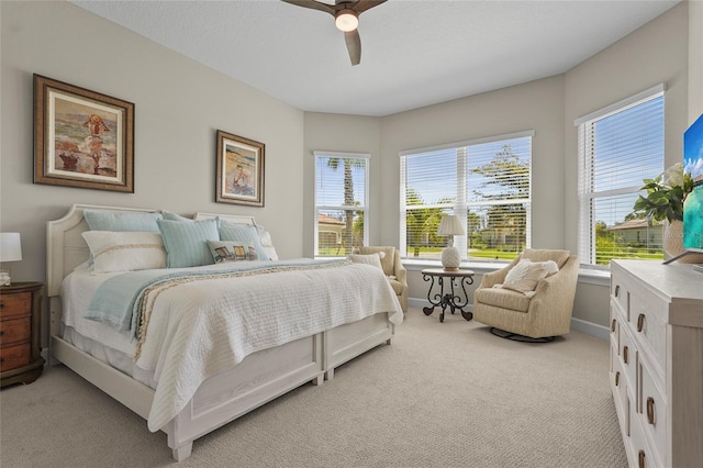 bedroom with light colored carpet, baseboards, and ceiling fan