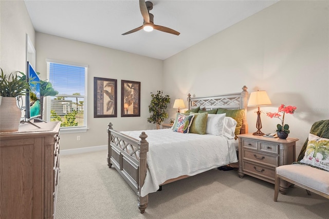 bedroom featuring a ceiling fan, baseboards, and light carpet