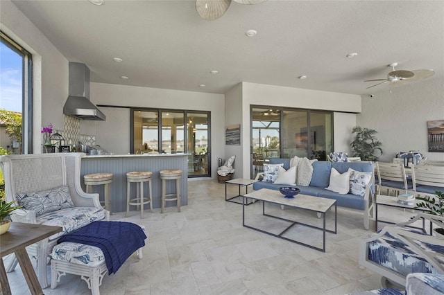 living area with a ceiling fan and a textured ceiling