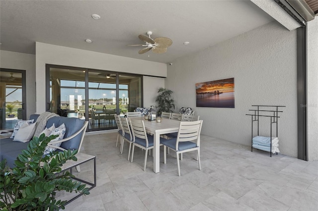 dining area featuring ceiling fan and a textured wall