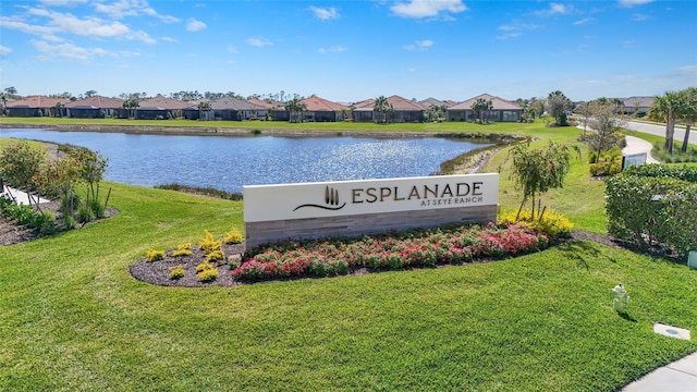 community / neighborhood sign with a yard, a water view, and a residential view