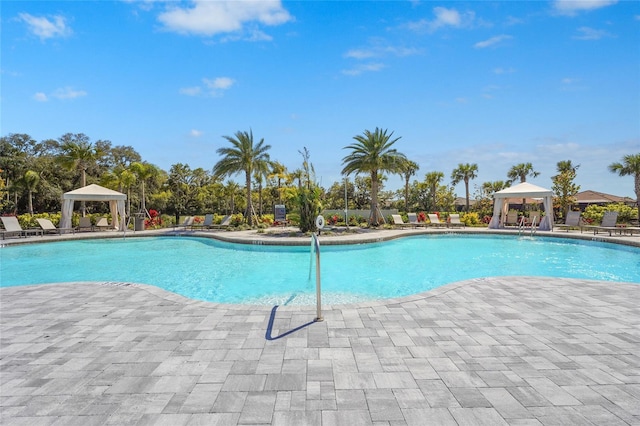 community pool with a gazebo and a patio