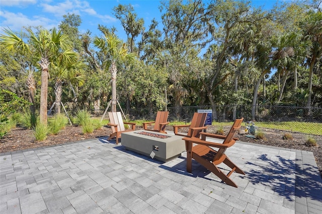 view of patio with an outdoor fire pit and fence