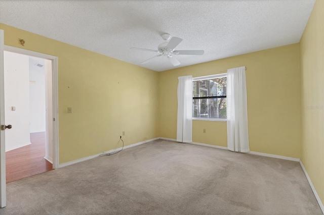 spare room with a textured ceiling, ceiling fan, and carpet flooring