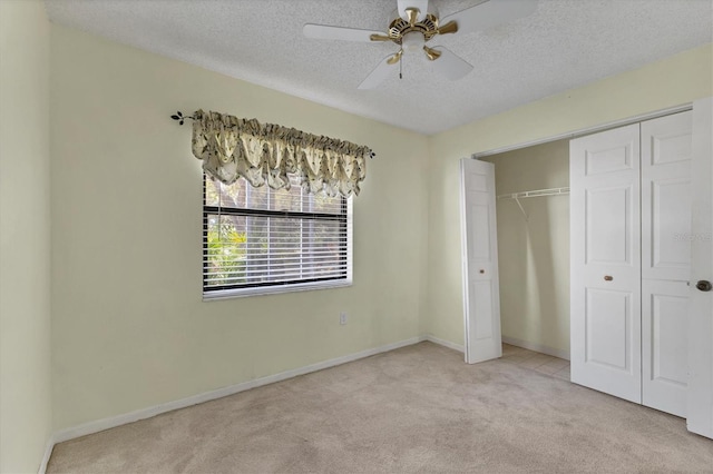 unfurnished bedroom with a ceiling fan, baseboards, a closet, a textured ceiling, and carpet flooring