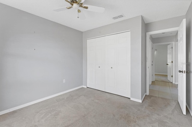 unfurnished bedroom featuring visible vents, baseboards, carpet floors, a closet, and a textured ceiling