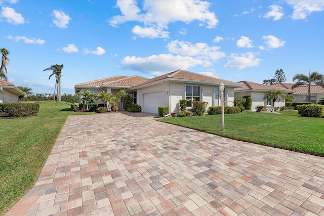 view of front of house with decorative driveway, a front yard, an attached garage, and stucco siding