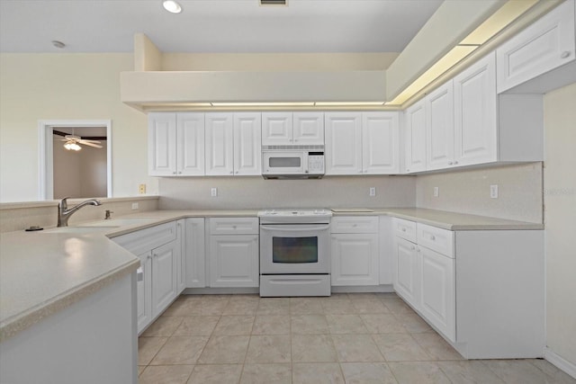 kitchen with a ceiling fan, a sink, white appliances, white cabinets, and light countertops