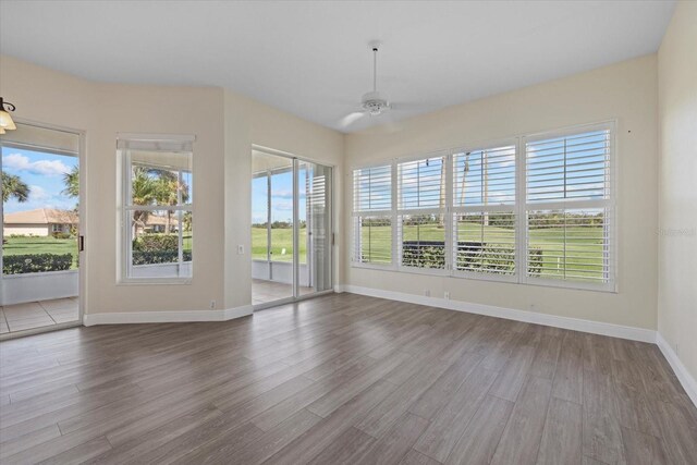 unfurnished sunroom featuring a healthy amount of sunlight and a ceiling fan