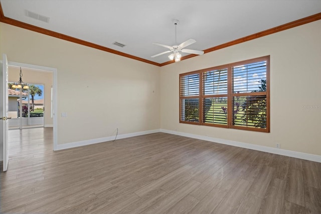 unfurnished room featuring visible vents, light wood-style flooring, baseboards, and ornamental molding