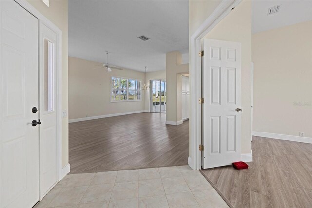 interior space featuring baseboards, light wood-style floors, visible vents, and ceiling fan