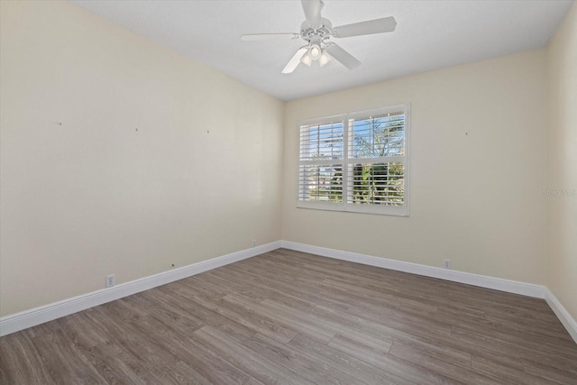 empty room featuring ceiling fan, baseboards, and wood finished floors