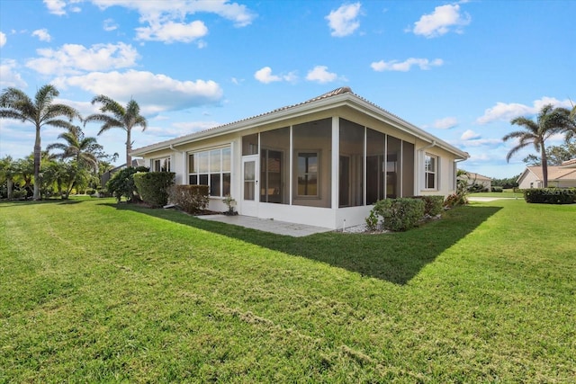 rear view of property featuring a yard and a sunroom