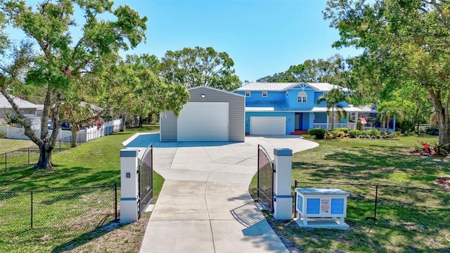 view of front of property featuring a front yard, driveway, a garage, a fenced front yard, and metal roof