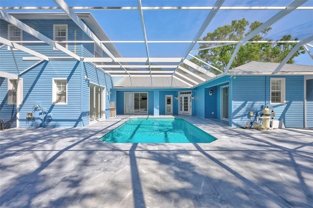 outdoor pool featuring a lanai, a patio area, and french doors