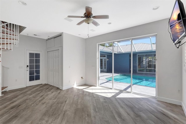 empty room with visible vents, ceiling fan, baseboards, and wood finished floors