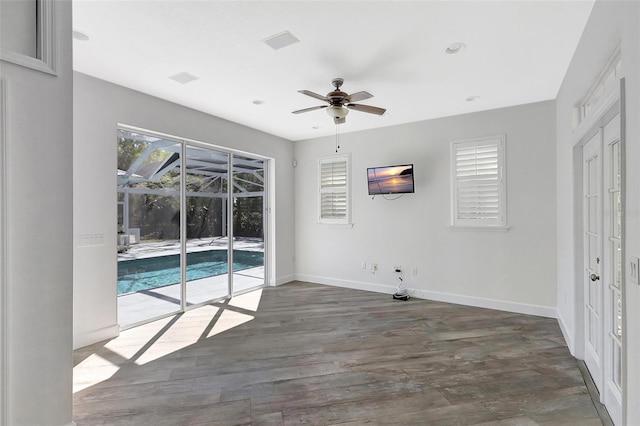 interior space featuring baseboards, wood finished floors, a ceiling fan, and a sunroom