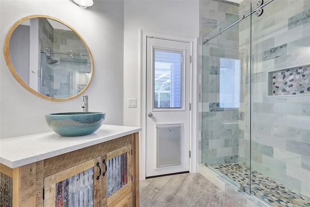 full bathroom featuring a shower stall, vanity, and wood finished floors