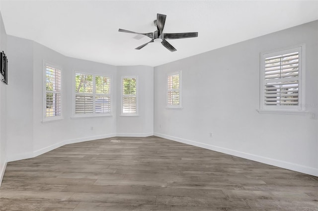 unfurnished room with ceiling fan, baseboards, and wood finished floors